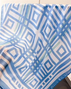 Detailed macro view of the blue geometric lattice pattern on a silk-like square scarf fabric