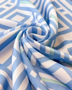 Detail of geometric blue and white patterned silk scarf with premium satin texture
