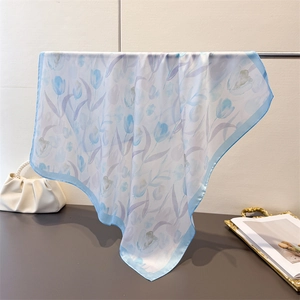 Detail of silk-like tulip print scarf draped over a stand showing smooth texture