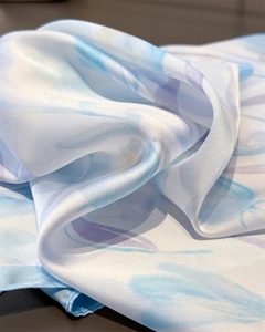 Macro detail of tulip print silk scarf showing smooth texture and soft watercolor patterns