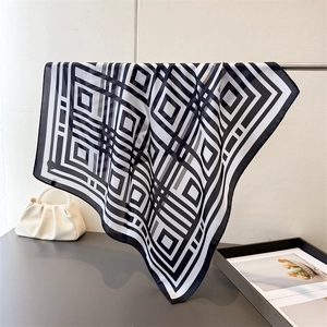 Detail view of large silk scarf featuring modern black and white geometric maze pattern