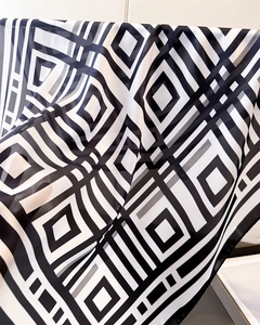 Macro detail of geometric black and white square pattern on lightweight chiffon silk scarf