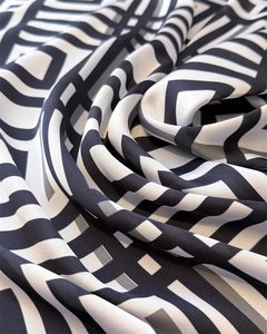 Macro shot of geometric black and white print silk scarf with luxury pleated texture