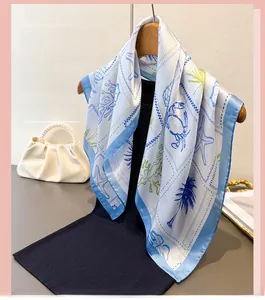 Detail of blue and white ocean pattern scarf with starfish, coral, and coconut tree prints