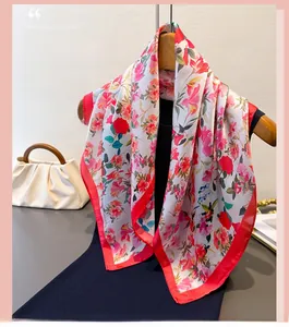 Dettaglio di un foulard in seta a stampa floreale con fiori rossi e trama satinata