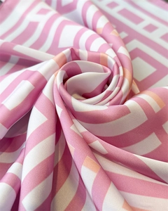 Detailed view of pink and white geometric silk-like scarf with a soft satin texture