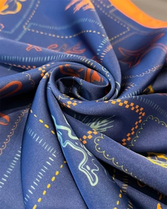 Detailed view of the ocean-inspired pattern and silky texture on navy blue square scarf