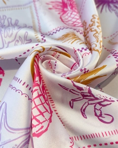 Macro detail of silk scarf showing vibrant ocean prints with crab and pineapple patterns