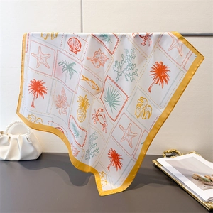 Detail of tropical ocean print silk scarf with starfish and palm tree patterns
