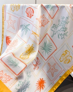 Detailed view of sea shell and palm tree prints on luxury white satin square scarf