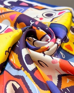 Macro shot of satin square scarf with colorful cartoon cat print and soft glossy finish