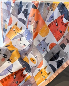 Detail showing smooth satin silk fabric with cartoon cat prints and soft drape texture