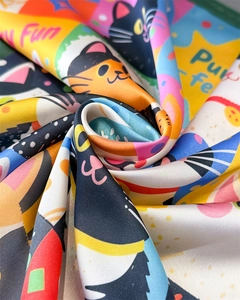 Detail of colorful satin scarf featuring cartoon cat prints and smooth silk texture