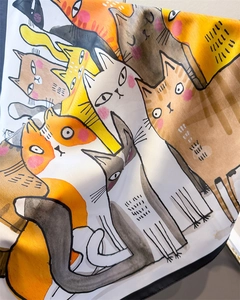 Detailed view of colorful cartoon cat print on a glossy silk-like satin square scarf