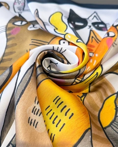 Close-up of silk-textured square scarf featuring vibrant cartoon cat illustrations