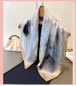 Detailed view of artistic grey-blue ink print silk scarf with golden rolled edges