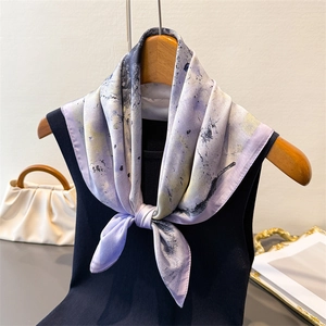 Detail of silk-like neck scarf with purple abstract ink wash pattern on a black vest