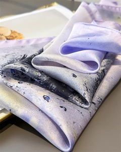 Detail of silk-like scarf featuring light purple and navy blue abstract art patterns