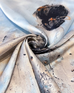Detailed texture of silk-like scarf with artistic ink-style maiden print and soft folds