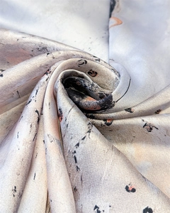 Close-up of elegant marble pattern silk scarf with soft beige and grey abstract print