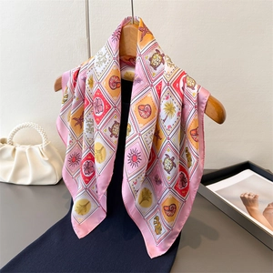 Tropical pattern silk scarf with ocean motifs hanging on wooden hanger with pearl bag