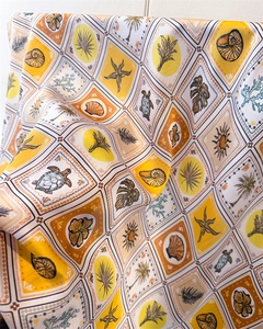 Macro detail of tropical marine print silk scarf featuring starfish and palm patterns