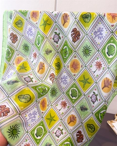 Detail of silk square scarf featuring nautical plaid patterns and tropical sea elements