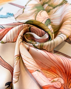 Detail of premium silk scarf fabric showing elegant floral print and smooth texture