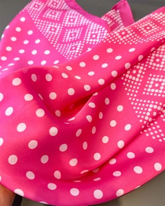 Texture détaillée d'un foulard en satin rose vif avec des pois et motifs géométriques