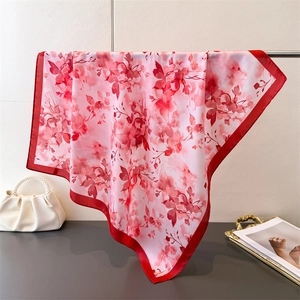Gros plan du foulard en soie à imprimé floral élégant avec bordure rouge et texture douce