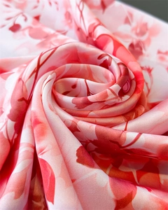 Vue détaillée d'un foulard en satin rose à fleurs avec une texture soyeuse et brillante