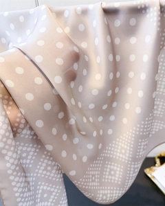 Détail du foulard en soie champagne transparent avec motifs géométriques à pois blancs