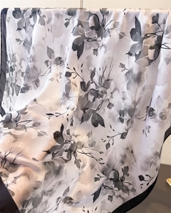 Gros plan détaillé d'un foulard en soie élégant avec motif floral noir et blanc satiné