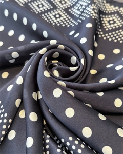 Macro d'un foulard en soie à pois géométriques avec texture lisse et drapé fluide