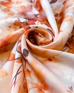 Détail macro du tissu en satin de soie montrant la texture lisse et le motif floral