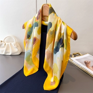 Elegant abstract print silk scarf in bright yellow with artistic colorful patterns