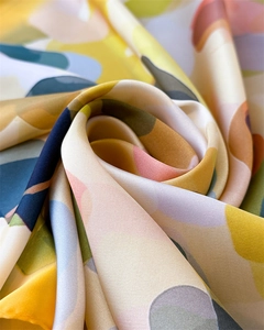 Detailed close-up of soft satin fabric showing abstract geometric print and draped texture