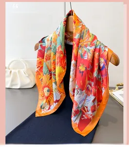 Detailed close-up of vibrant tropical floral print silk scarf with orange borders