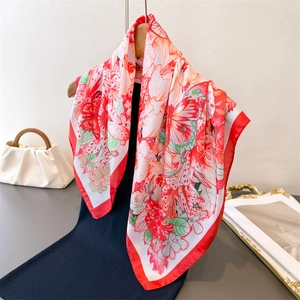 Red and white floral silk scarf with butterfly print hanging on a hanger for styling