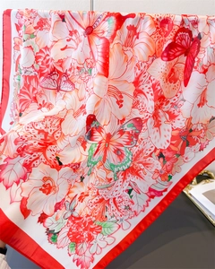 Detail of floral butterfly print silk-like scarf with red border and smooth satin texture