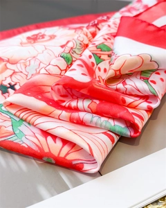 Detailed macro view showing the silk-like texture and floral print of this elegant scarf
