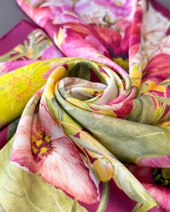 Macro view of floral silk scarf featuring vibrant digital prints and smooth satin texture