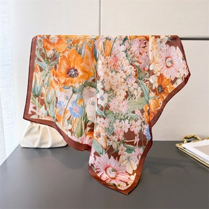 Close-up of silk-like floral scarf with orange tulips and elegant satin texture finish