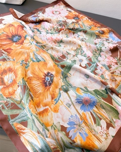 Detailed macro view of vintage floral print satin scarf with hand-rolled edges and rich colors