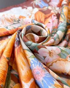 Macro shot of colorful floral print silk scarf with smooth glossy texture and detail