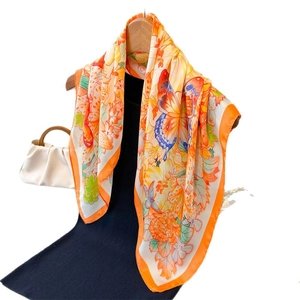 Elegant floral butterfly silk scarf in orange and yellow draped over a blue dress