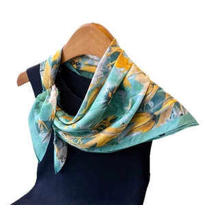 Floral print silk scarf in blue and yellow draped on black sleeveless top