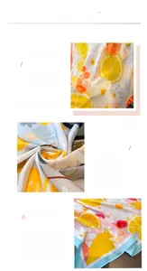 Détail des motifs de citrons et fleurs sur foulard satiné avec bordure finement cousue
