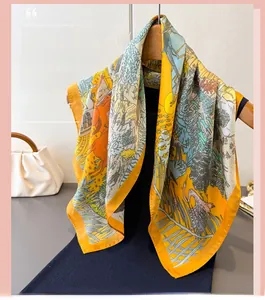Close-up of animal flora print on warm yellow silk scarf with smooth glossy texture