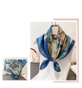 Close-up of royal blue and yellow silk scarf featuring detailed animal and floral prints